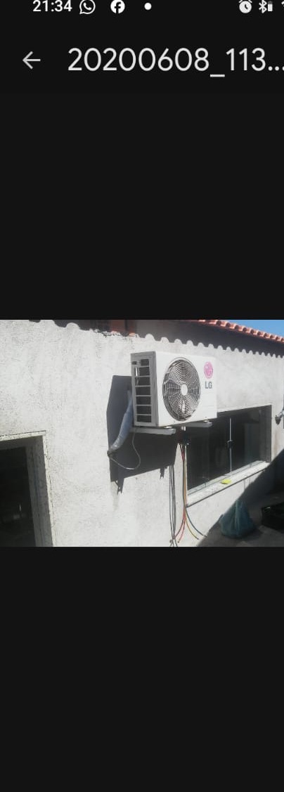 duas condensadoras de ar-condicionado LG instaladas na parede externa de uma fachada com telhado de telhas