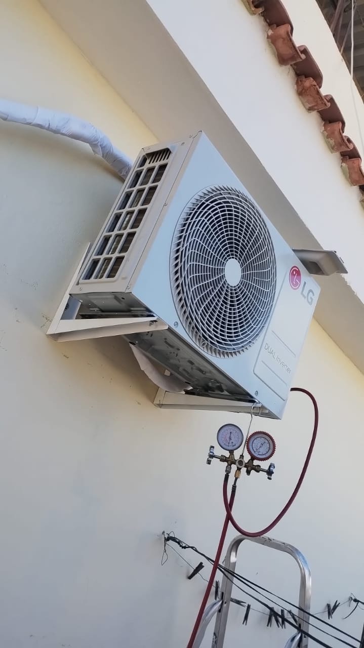 condensadora de ar-condicionado LG Dual Inverter instalada na parede externa com manômetros de gás conectados